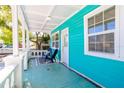Inviting front porch with classic balustrade, blue tile flooring, and chairs, creating a cozy outdoor space at 56 W Park St, Tarpon Springs, FL 34689