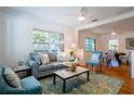 Bright living room featuring hardwood floors, ceiling fan, large windows, and stylish decor, creating a welcoming atmosphere at 56 W Park St, Tarpon Springs, FL 34689