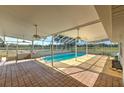 Screened-in pool area features an outdoor bar, ceiling fans, and views of the surrounding horse pastures at 6709 W Knights Griffin Rd, Plant City, FL 33565