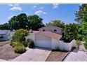 Two-story home with an attached garage, nicely landscaped yard, and paved driveway on a sunny day at 7307 Summerbridge Dr, Tampa, FL 33634