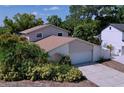 Two-story home shows an attached garage and nicely landscaped yard on a sunny day at 7307 Summerbridge Dr, Tampa, FL 33634