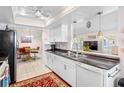 Bright kitchen featuring white cabinetry, dark countertops, and an adjacent breakfast nook at 9110 34 N Way, Pinellas Park, FL 33782