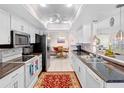 Well-maintained kitchen featuring white cabinets, granite countertops, and modern appliances at 9110 34 N Way, Pinellas Park, FL 33782