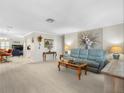 Open living room with a light blue sofa, decor lighting, and a beautiful floral design painting at 9110 34 N Way, Pinellas Park, FL 33782