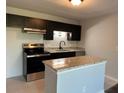 Well-appointed kitchen with granite countertops, stainless steel appliances, and black cabinetry at 10200 Gandy N Blvd # 1133, St Petersburg, FL 33702