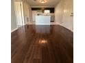 Open-concept living room with stylish wood floors and a view into the modern kitchen at 10200 Gandy N Blvd # 1133, St Petersburg, FL 33702