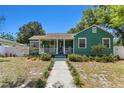 Inviting home features a covered porch with seating and lush landscaping at 1046 Yale N St, St Petersburg, FL 33713