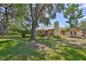 Beautiful exterior of a stone home with well-maintained lawn and mature trees at 10824 Palmetto St, Riverview, FL 33569
