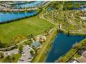 Aerial view of a community park with a playground, baseball field, and a lake at 12026 Medley Ter, Lakewood Ranch, FL 34211