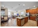 Open-concept kitchen featuring a large island, granite countertops, stainless steel appliances, and an adjacent living area at 1227 Ballard Green Pl, Brandon, FL 33511