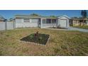Charming single-story home with a screened-in porch, an attached garage, and front yard at 1264 Chelsea Ln, Holiday, FL 34691