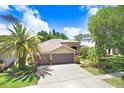 Charming home featuring a three-car garage, well-maintained landscaping, and a concrete driveway at 16118 Lytham Dr, Odessa, FL 33556