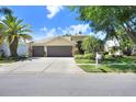 Charming home featuring a three-car garage, well-maintained landscaping, and a concrete driveway at 16118 Lytham Dr, Odessa, FL 33556