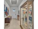 Bright foyer featuring sleek tile flooring, art display and a decorative display cabinet at 17583 Holly Well Ave, Wimauma, FL 33598
