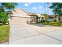 Street view showcasing the home's facade, large driveway, three-car garage, and landscaped front yard at 18310 Bankston Pl, Tampa, FL 33647