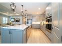 Spacious kitchen with light gray cabinets, a center island, and stainless steel appliances at 19442 Sea Glass Cir, Land O Lakes, FL 34638