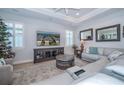 Bright living room featuring a large TV, comfortable seating, and plantation shutters at 19442 Sea Glass Cir, Land O Lakes, FL 34638