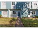 Townhome with a grassy front yard and concrete walkway leading up to the front door at 195 114Th Ne Ave # 195, St Petersburg, FL 33716
