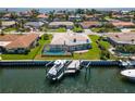 Stunning aerial view of a waterfront property featuring a screened pool, lush green lawn, private boat dock, and canal access at 2015 Hawaii Ne Ave, St Petersburg, FL 33703