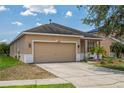 Front exterior view of a house with a two-car garage and well-maintained lawn at 20606 Whitewood Way, Tampa, FL 33647