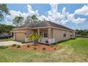 Exterior side view of home showing tan stucco, landscaping, and view of the lake at 20606 Whitewood Way, Tampa, FL 33647