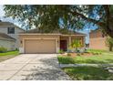 Charming single-story home featuring a well-manicured lawn, a two-car garage, and decorative landscaping at 20606 Whitewood Way, Tampa, FL 33647