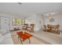 Open-concept living area with hardwood floors, a dining area, lots of natural light, and stylish furnishings at 225 Cevera Dr, Dunedin, FL 34698