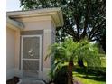 Elegant home entrance with a decorative screen door featuring a heron design, complemented by lush landscaping at 2333 Brookfield Greens Cir, Sun City Center, FL 33573