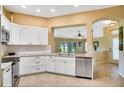 Modern kitchen with white cabinets, stainless steel appliances, granite countertops, and tile flooring at 2333 Brookfield Greens Cir, Sun City Center, FL 33573