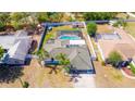 Aerial view of home with a screened-in pool, fenced yard, mature landscaping, and a private backyard at 2435 Comerwood Dr, Spring Hill, FL 34609