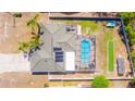 Overhead aerial view of the property showcasing a screened-in pool, solar panels and fenced yard at 2435 Comerwood Dr, Spring Hill, FL 34609