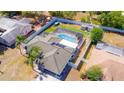 Aerial view featuring a screened-in pool, fenced yard, mature landscaping, and a storage shed at 2435 Comerwood Dr, Spring Hill, FL 34609