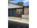 Charming condo exterior with brick facade, a small window, and twin bright blue doors at 24862 Us Highway 19 N # 2303, Clearwater, FL 33763
