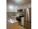 Well-lit kitchen features stainless steel appliances, white cabinets, and subway tile backsplash at 24862 Us Highway 19 N # 2303, Clearwater, FL 33763