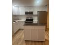 Modern kitchen featuring white cabinets, stainless steel appliances, and a functional center island at 24862 Us Highway 19 N # 2303, Clearwater, FL 33763