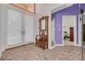 Inviting foyer with stone floors, a charming hall tree, and double French doors leading to outdoor spaces at 2613 59Th S St, Gulfport, FL 33707