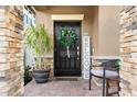 Inviting front entrance with a stylish black door, decorative wreath, and welcoming 'WELCOME' sign at 28638 Tranquil Lake Cir, Wesley Chapel, FL 33543