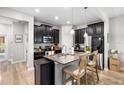 Modern kitchen with dark cabinetry, granite countertops, stainless steel appliances, and an island with seating at 28638 Tranquil Lake Cir, Wesley Chapel, FL 33543