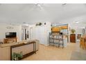 Open-concept living area features neutral tones, tile flooring and easy access to kitchen with breakfast bar at 2903 W Paxton Ave, Tampa, FL 33611