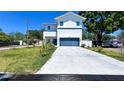 Modern two-story home featuring a gray garage door, fresh landscaping, and a long driveway at 3605 W Anderson Ave, Tampa, FL 33611