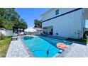 Backyard pool with lounge chairs, an umbrella, and a privacy fence providing a relaxing outdoor space at 3605 W Anderson Ave, Tampa, FL 33611