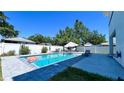 Outdoor pool with brick patio and furniture, surrounded by a white privacy fence and lush greenery at 3605 W Anderson Ave, Tampa, FL 33611
