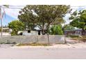 Street view of the distressed house and fenced front yard with mature trees at 4111 W Marietta St, Tampa, FL 33616