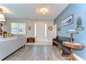 Inviting entryway features wood-look floors, soft lighting, and a decorative bench at 4444 Devinshire Fields Loop, Plant City, FL 33567