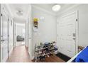 Inviting entryway with wood floors and coat rack with shoe storage at 5302 Aloha Seed Dr, Seffner, FL 33584