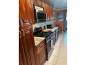 Well-lit kitchen features granite countertops, tiled backsplash, stainless steel appliances, and wooden cabinets at 6190 80Th N St # 204, St Petersburg, FL 33709