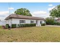 Side view of the home featuring a well-manicured lawn and mature landscaping at 8721 Bay Crest Ln, Tampa, FL 33615
