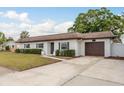 Charming single-story home with a well-manicured lawn, clean design, and a two-car garage at 8721 Bay Crest Ln, Tampa, FL 33615
