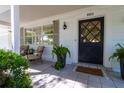 Welcoming front porch with tiled flooring, comfortable seating, and a stylish front door at 880 Phyllis Ave, Largo, FL 33771