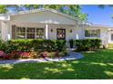 Charming home featuring a covered front porch with elegant pillars and meticulously landscaped front yard at 880 Phyllis Ave, Largo, FL 33771